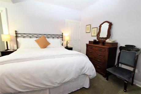 bed with white linens and dresser