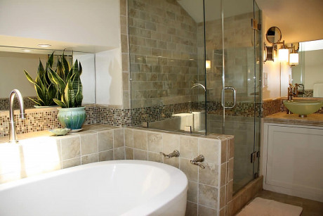 stone bathroom with soaking tub, shower and sink area